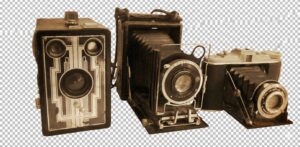 Three vintage film cameras arranged in a row against an abstract, swirling sepia-toned background. From left to right: a black Art Deco-style box camera, a large folding camera with extended bellows and a prominent lens, and a compact folding camera with a silver top plate